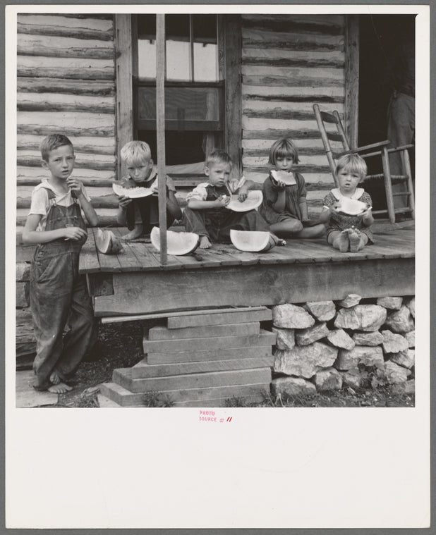 Millworker's children eating watermelon on porch of rented house. Six miles north of Roxboro, Person County, North Carolina