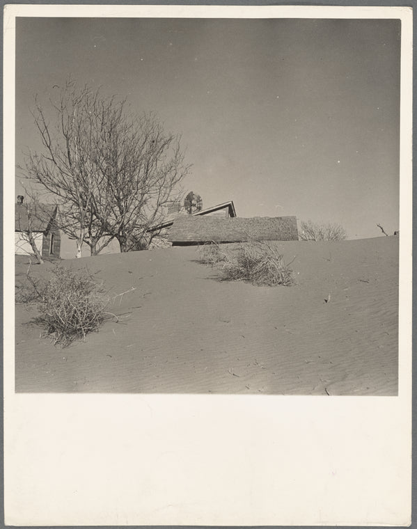 Large drifts of good Kansas top soil threaten to cover up this farmer's home. Kansas