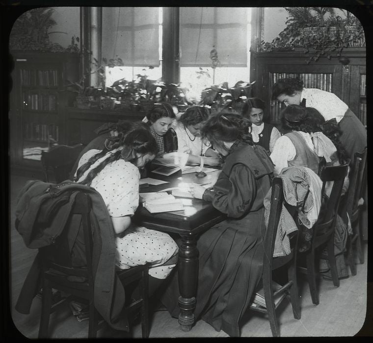 Work with schools, Tompkins Square : girls working at table : a class visit, 1910s