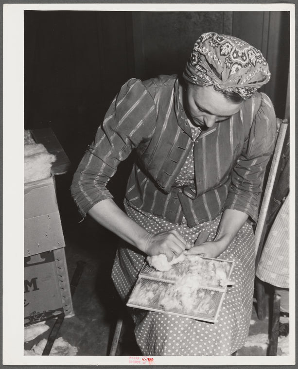 Woodville, California. FSA (Farm Security Administration) farm workers' community. Carding surplus cotton which will be used for quilts