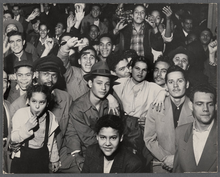 Large crowd of people smiling, some with raised hands