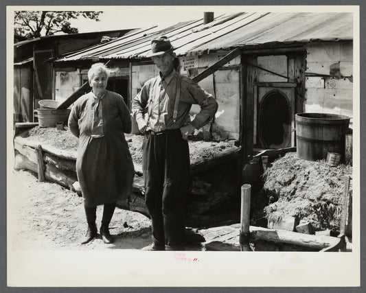 Mr. and Mrs. Thompson standing in front of their log and peat cabin. Thompson reckoned that he had had three crops out of nine on the land. Necedah project, Wisconsin.