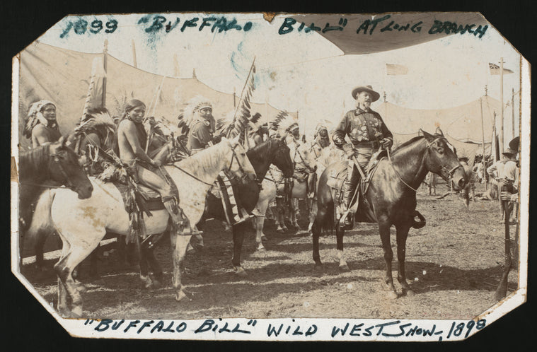 William F. Cody, right, on horseback
