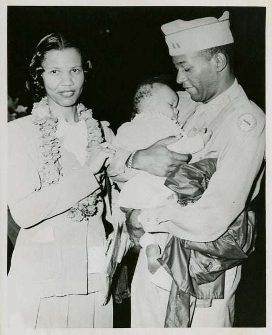 African American officer standing next to his wife and holding his baby son in his hands, Honolulu