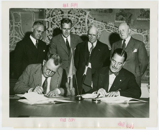 Norway Participation - Frederik Odfjell (Commissioner General) and Grover Whalen signing contracts while group looks on