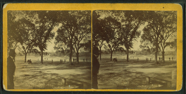 View of people in Boston Common including a man in a tophat in the foreground.
