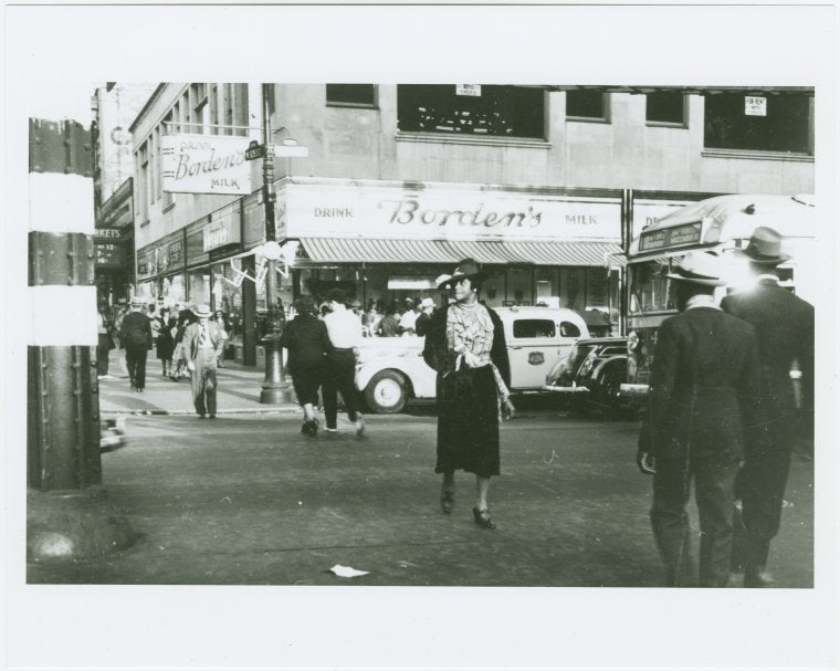 Woman crossing street in Harlem at West 125th Street and Eighth Avenue, 1939