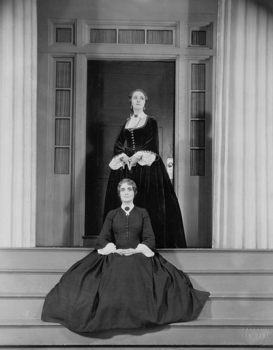 Elizabeth Risdon as Christine (standing) and Leona Hogarth  as Lavinia (seated, on steps of Mannon Mansion). Costume and set designed by Robert Edmond Jones.
