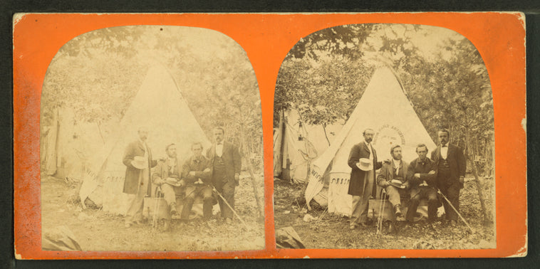 Four men in front of a tent with a sign for the Boston Daily Advertiser.