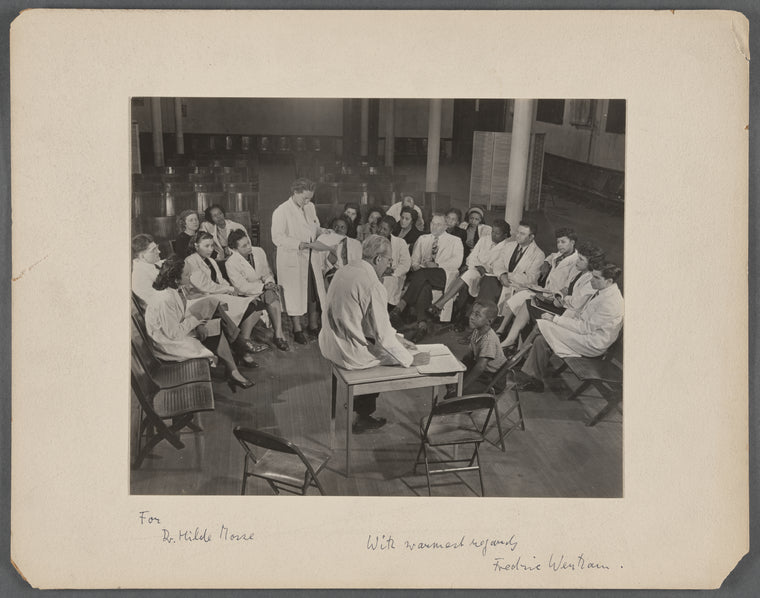 Group portrait of doctors in white coats including Hilde Mosse and Fredric Wertham examining a child