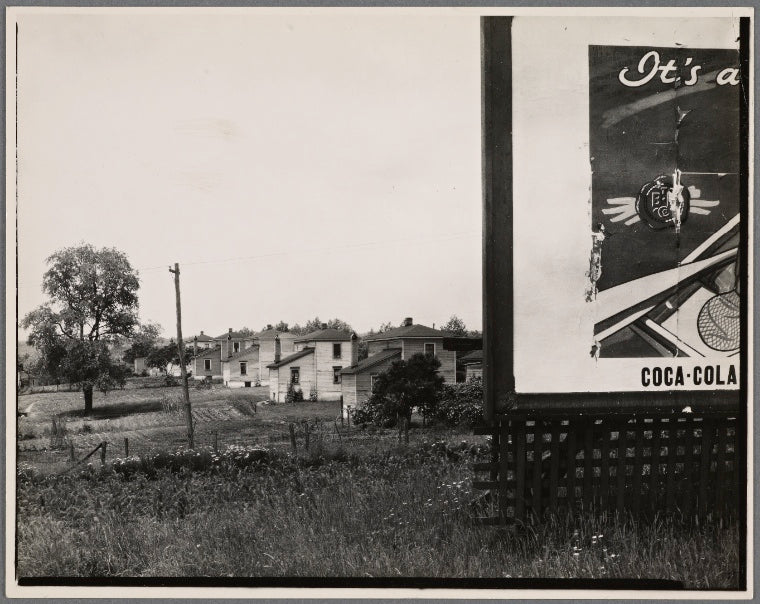 Houses with partial view of billboard advertising Coca-Cola in foreground. West Virginia?