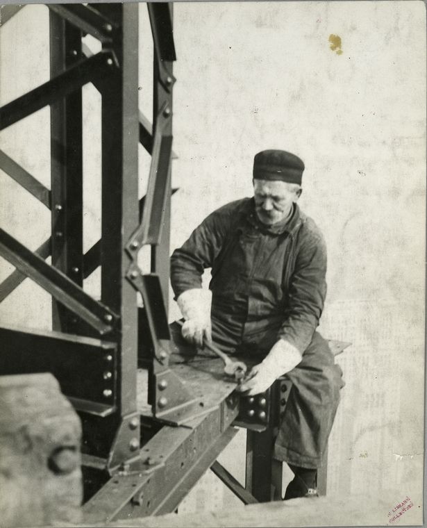 Worker attaching a bolt onto a beam