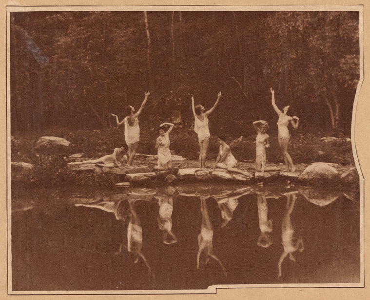 Dancers in Greek poses by the water
