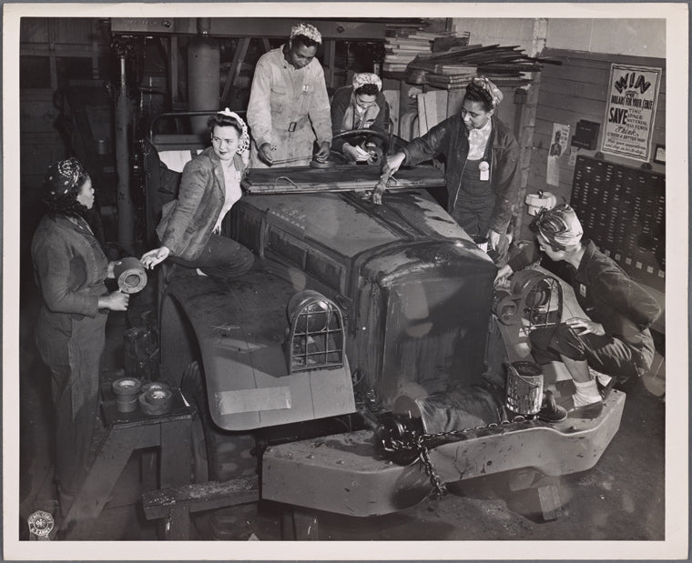 Female workers preparing army truck for shipment overseas
