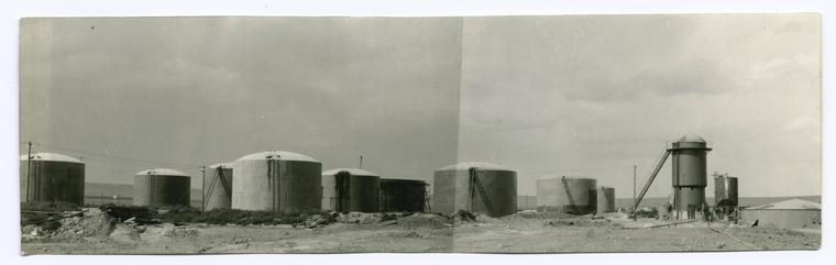View of storage tanks and agitator and bleachers, Sunburst Refinery.