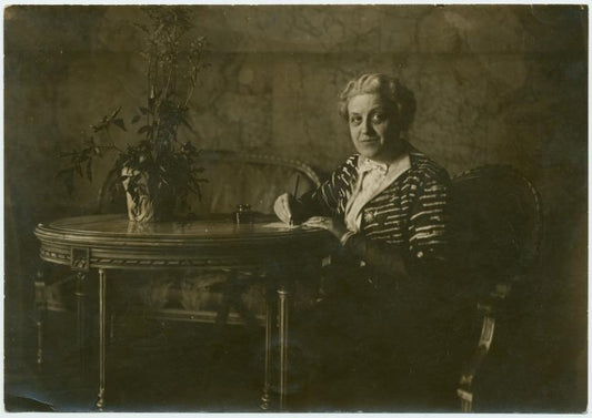 Carrie Chapman Catt, writing at a table.