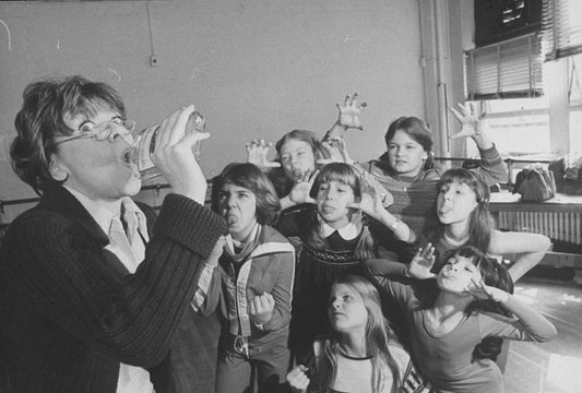 Actress Dorothy Loudon having a drink as she is surrounded by orphan girls incl. Andrea McArdle (2L) as Little Orphan Annie during a rehearsal for the Broadway production of the musical "Annie.".