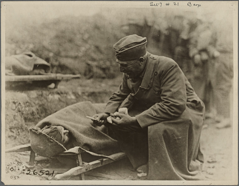 “Soldier offering wounded comrade a cigarette…”