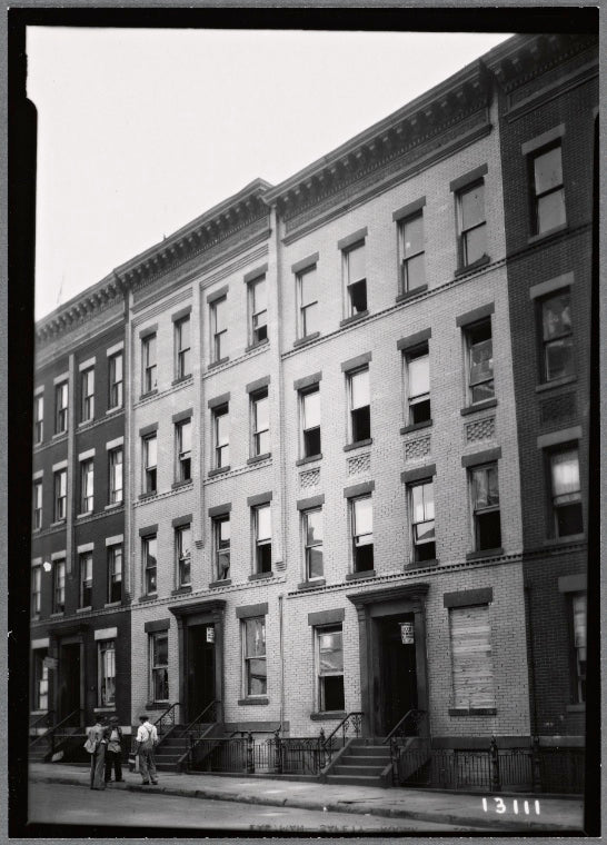 Tenements under renovation; workers outside