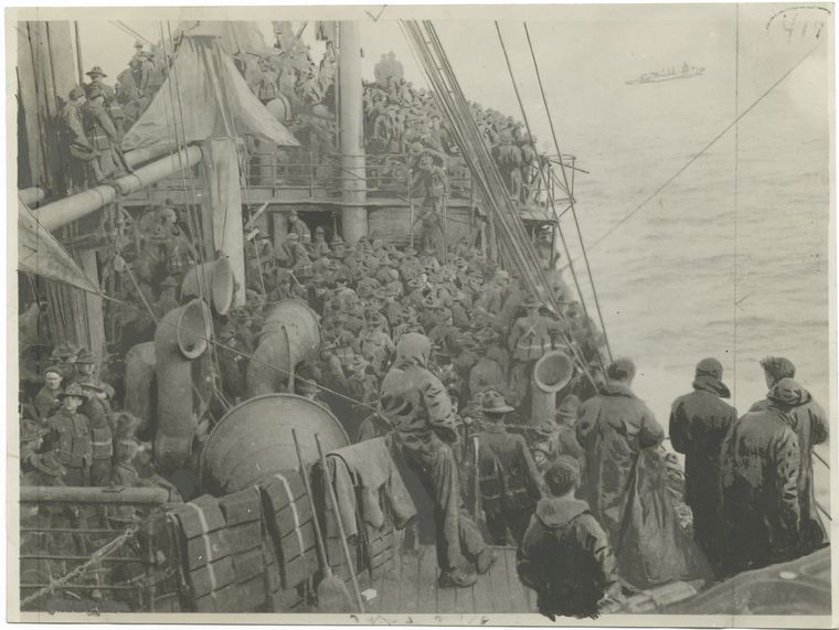 Men on a United States transport watching an encounter with a submarine.