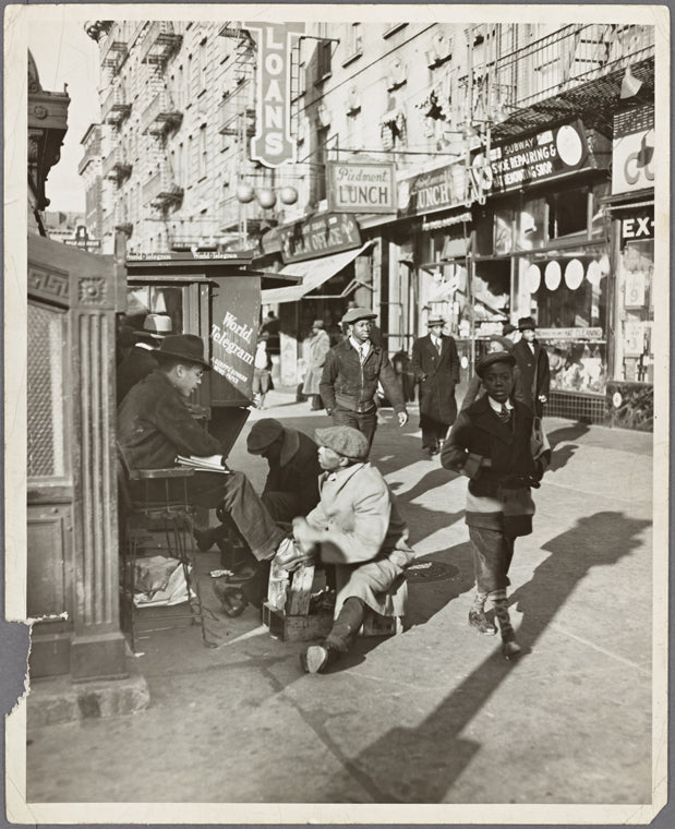 View of Lenox Avenue, Harlem, at 135th Street, showing businesses, pedestrians and shoe-shine stand, March 23, 1939