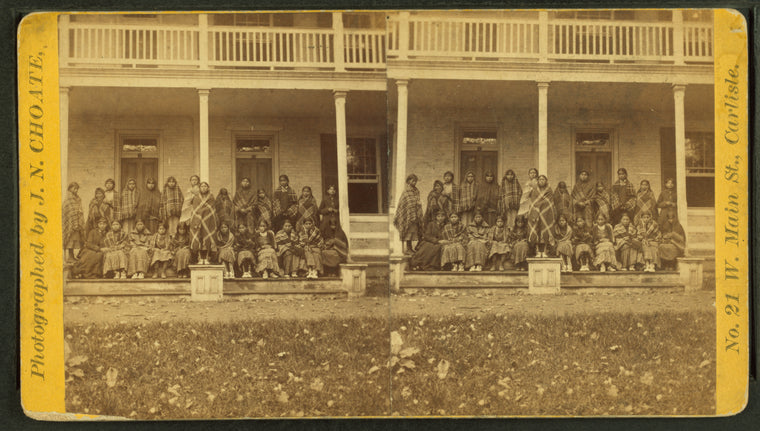 Group portrait of Native American students on the steps of the United States Indian Industrial Training School.