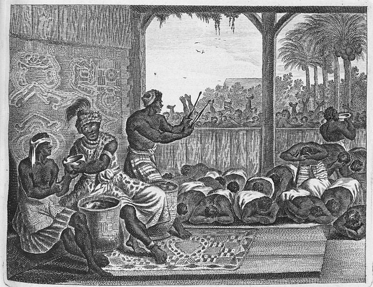 [A group of men bowed down participating in ceremony.]