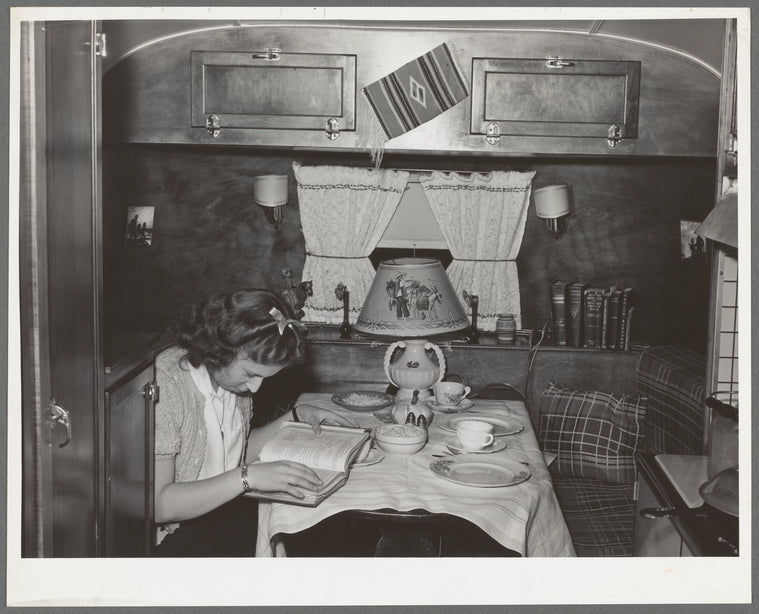 End of trailer with high school girl studying as she waits for supper time. San Diego, California. Trailer courts dot the outskirts of San Diego and the majority of the workmen seem to be living in trailers