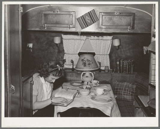 End of trailer with high school girl studying as she waits for supper time. San Diego, California. Trailer courts dot the outskirts of San Diego and the majority of the workmen seem to be living in trailers