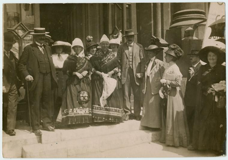 Members on the steps with women in local costume.