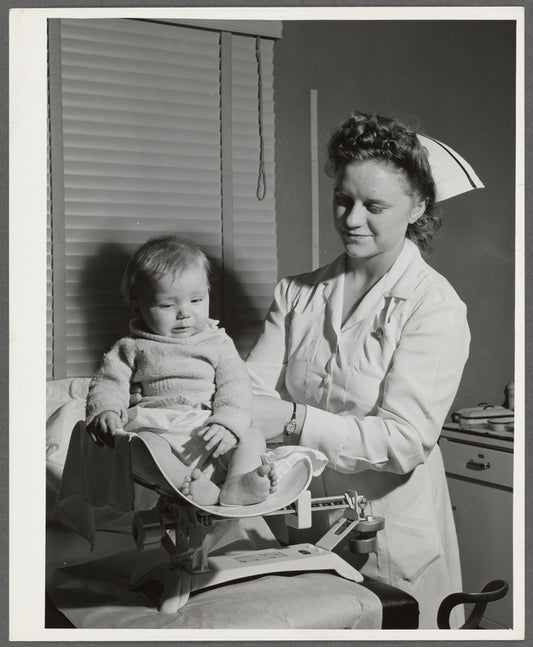 Nurse weighs baby at the well baby clinic at the Cairns General Hospital at the FSA (Farm Security Administration) farm workers' community. Eleven Mile Corner, Arizona