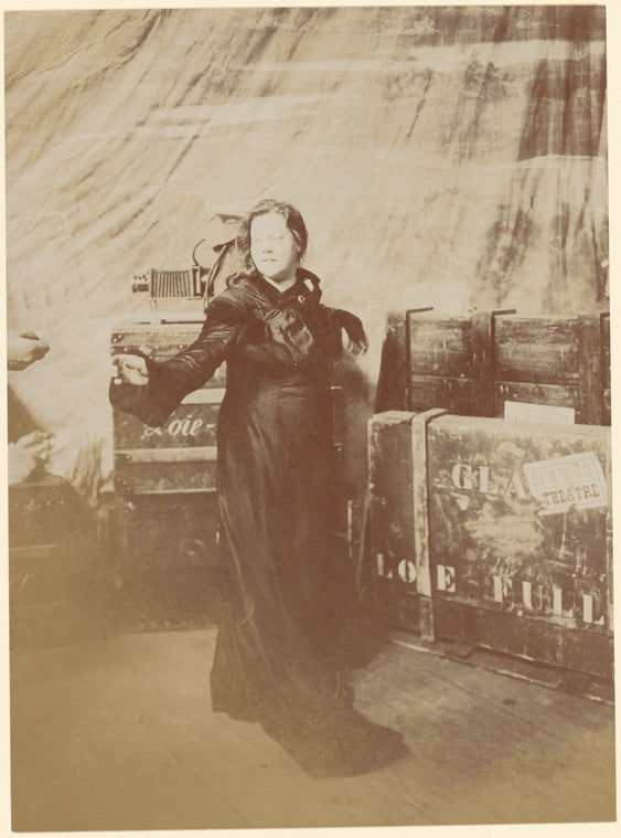 Loie Fuller standing with suitcases