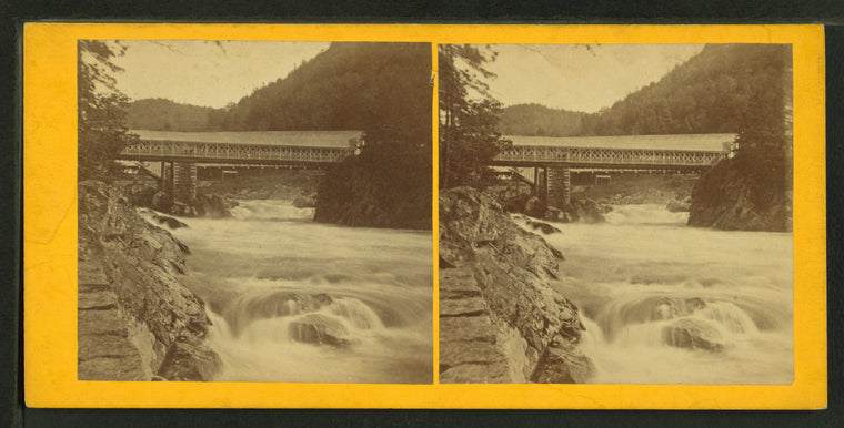 View of a bridge over a rushing stream.
