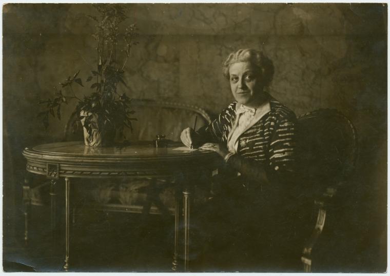 Carrie Chapman Catt, writing at a table.