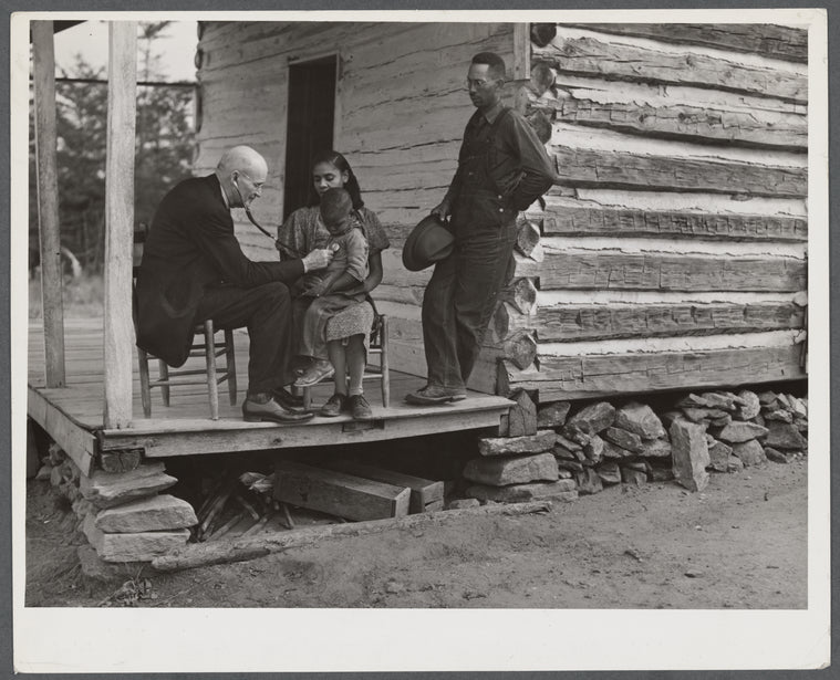 Dr. S.A. Malloy examining Louis Graves and his family on their front porch. They are FSA (Farm Security Administration) borrowers. Caswell County, North Carolina.
