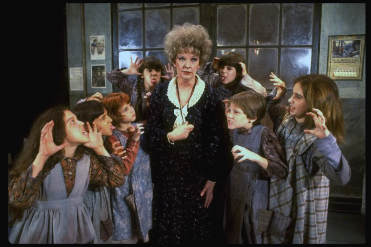 Actress Patricia Drylie as Miss Hannigan w. orphans in a scene from the Dallas production of musical "Annie."