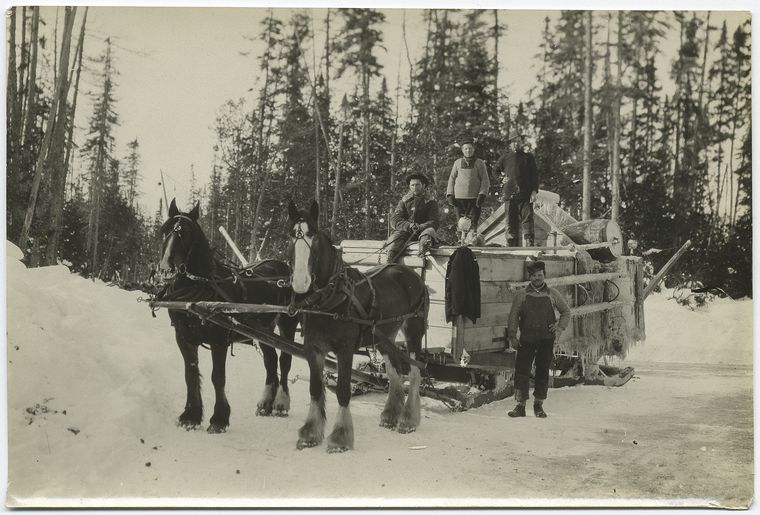 Horse drawn sled carrying a large load.