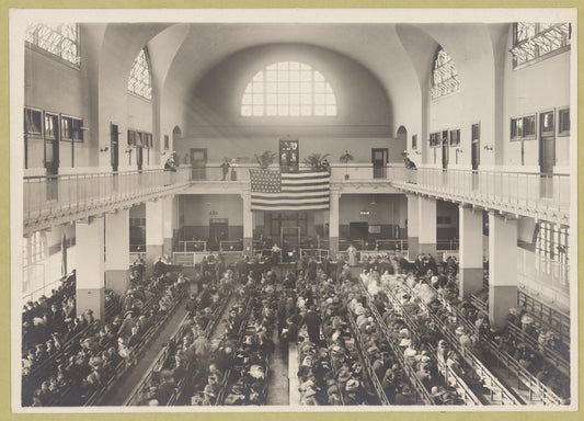 Immigrants seated on long benches, Main Hall, U.S. Immigration Station