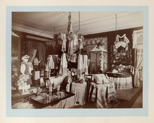 Large room with displays of embroidery towels, tableclothes, pillow cases, costumes, dolls and napkins, etc.