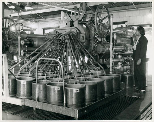 African American woman operating a large piece of machinery.