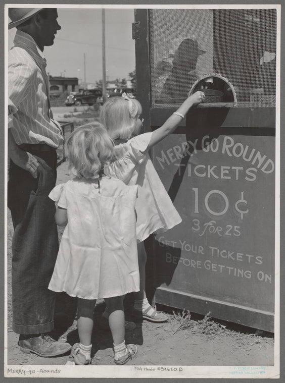 Little girls getting tickets for the merry-go-round at the carnival on the Fourth of July. Vale, Oregon