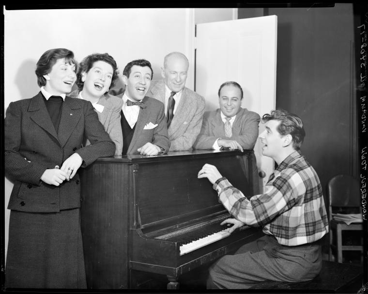 Betty Comden, Rosalind Russell, Adolph Green, George Abbott, Lehman Engel, and Leonard Bernstein (at piano) in rehearsal for the stage production Wonderful Town, 1953.
