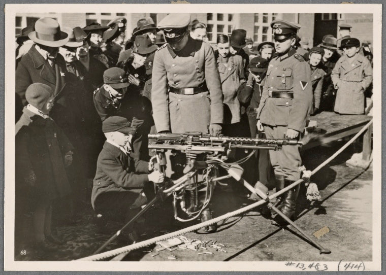 On Armed Forces Day, the barracks were opened to visitors, and people were allowed to shoot (in return) for (a contribution to) the War Winter Relief.  Here, members of the youngest military (age-)group sit at a machine gun.