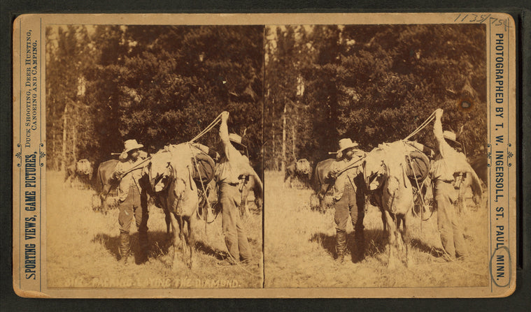 Men tying packs on horses.