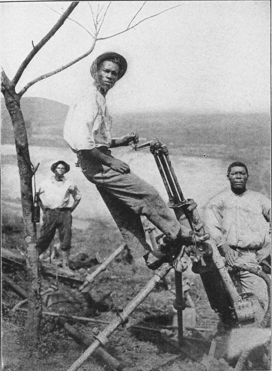 Jamaicans operating a compressed air drill.