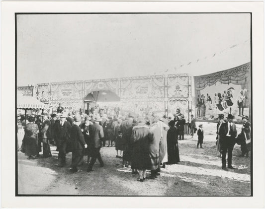 C.W. Parker Amusement Company operated carnival, ca. 1920s. Signage for burlesque shows, as well as groups of stage performers, are in the far background