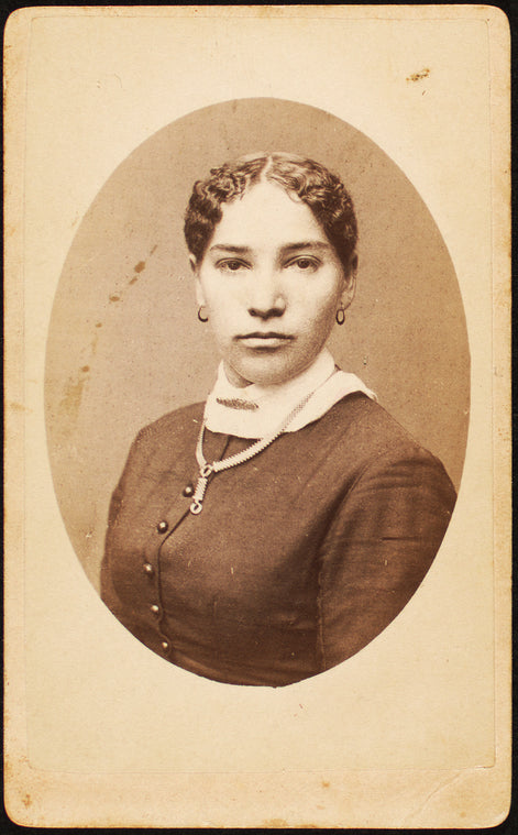 Studio portrait of young woman wearing chain necklace.