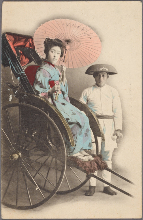 Studio portrait of young woman in ricksaw posed with driver.