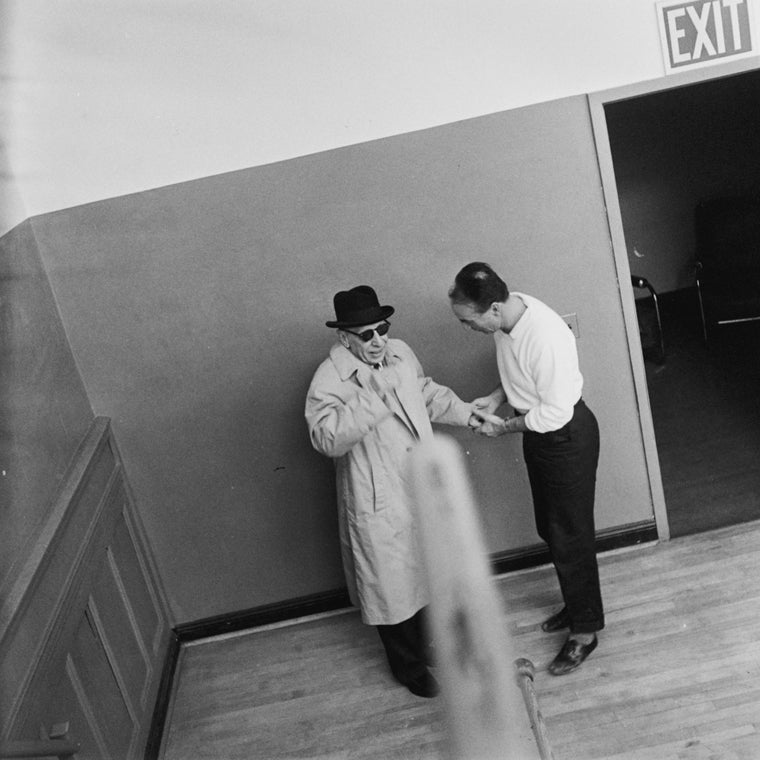 Choreographer George Balanchine (R) greeting composer Igor Stravinsky (L) in stairwell of School of American Ballet studios for rehearsal of New York City Ballet production of "Agon" (New York)