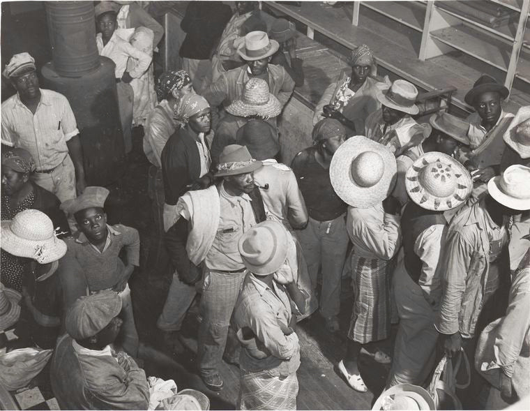 Negro day laborers brought in by truck from nearby towns, waiting to be paid off and buy supplies, for cotton picking inside plantation store, Friday night, Marcella Plantation, Mileston, Mississippi Delta, Mississippi, October 1939.